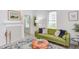 Inviting living room with green sofa, wood coffee table, and neutral decor, filled with natural light at 919 Orient St, Durham, NC 27701