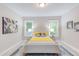 Bright main bedroom with stylish decor, two windows, and wood-look floors at 919 Orient St, Durham, NC 27701