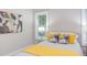 Close-up of a cozy main bedroom featuring two windows, colorful bed decor, and wood-look floors at 919 Orient St, Durham, NC 27701