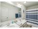 Bright bathroom with double sinks, white cabinets, large mirror and shower with a striped curtain at 101 Yuma Dr, Louisburg, NC 27549