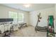Carpeted bedroom featuring desk, work out equipment, a window, and a white door in a neutral color scheme at 101 Yuma Dr, Louisburg, NC 27549