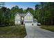 Charming home featuring a three-car garage, well-manicured lawn, and lush, surrounding trees at 101 Yuma Dr, Louisburg, NC 27549