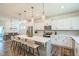 Open concept kitchen with stainless steel appliances, white cabinetry, hardwood floors, and pendant lights over center island at 101 Yuma Dr, Louisburg, NC 27549