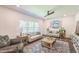 Bright living room featuring hardwood floors, neutral paint, multiple sofas, and natural light from large windows at 101 Yuma Dr, Louisburg, NC 27549