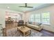 Living room and kitchen layout with hardwood flooring, neutral walls, bright windows, stylish furnishing, and ceiling fan at 101 Yuma Dr, Louisburg, NC 27549