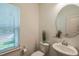 Well-lit half bathroom with a modern sink, toilet, and window with blinds at 101 Yuma Dr, Louisburg, NC 27549