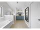 Elegant bathroom with double vanity, tub, walk-in shower, and neutral tile floors at 1010 Smoke Willow Way, Rolesville, NC 27571