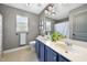 Well-lit bathroom with double sinks, modern fixtures, and a shower featuring a patterned curtain at 1010 Smoke Willow Way, Rolesville, NC 27571