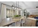 Sunlit dining area featuring a modern chandelier, a farmhouse table, and access to an outdoor patio at 1010 Smoke Willow Way, Rolesville, NC 27571
