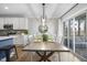 Dining area with wood floors, modern lighting and seating for four, adjacent to the modern kitchen area at 1010 Smoke Willow Way, Rolesville, NC 27571