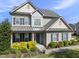 Inviting two-story home with a beautiful front yard featuring mature landscaping and a welcoming blue front door at 1010 Smoke Willow Way, Rolesville, NC 27571