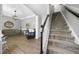 Bright foyer with staircase and view into the adjacent seating area with wood floors and fresh paint at 1010 Smoke Willow Way, Rolesville, NC 27571