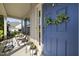 Charming front porch featuring a blue front door, lovely floral arrangements, and comfortable seating area at 1010 Smoke Willow Way, Rolesville, NC 27571
