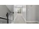 Well-lit hallway with neutral walls, carpet flooring, and a view towards the end of the hallway at 1010 Smoke Willow Way, Rolesville, NC 27571