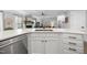 Bright kitchen featuring white cabinets, quartz countertop, and stainless steel appliances with open concept to the living area at 1010 Smoke Willow Way, Rolesville, NC 27571