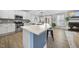 Modern kitchen featuring stainless steel appliances, gray backsplash, stylish lighting, and a spacious center island at 1010 Smoke Willow Way, Rolesville, NC 27571