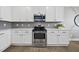 Updated kitchen showcasing white cabinets, stainless steel appliances, and stylish gray subway tile backsplash at 1010 Smoke Willow Way, Rolesville, NC 27571