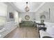 Bright living room with wood floors, fresh paint, and attractive furniture arrangement beneath modern chandelier at 1010 Smoke Willow Way, Rolesville, NC 27571