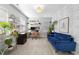 Bright home office featuring a comfortable blue velvet couch, houseplants, and a modern desk at 1010 Smoke Willow Way, Rolesville, NC 27571