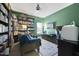 Home office or library featuring floor-to-ceiling bookshelves, a comfortable couch, and a dedicated workspace at 1010 Smoke Willow Way, Rolesville, NC 27571