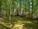 Lush backyard with mature trees casting shadows on the lawn and partially obscuring the house at 102 Treadwell Ct, Cary, NC 27513