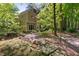 Backyard with a stream, mature trees, and stone walkway at 102 Treadwell Ct, Cary, NC 27513