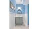 Charming powder room with beadboard wainscoting, blue walls, and a gray vanity with an oval mirror at 102 Treadwell Ct, Cary, NC 27513