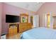 Bright bedroom with vaulted ceiling featuring a TV console and open closet and bathroom at 102 Treadwell Ct, Cary, NC 27513