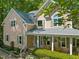 Charming two-story home featuring a welcoming front porch with seating, lush landscaping, and classic architectural details at 102 Treadwell Ct, Cary, NC 27513