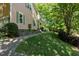 Manicured lawn and walkway showcasing the side of this lovely home and wooded lot at 102 Treadwell Ct, Cary, NC 27513