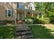 Attractive two-story home with a welcoming front porch, lush greenery, and stone steps at 102 Treadwell Ct, Cary, NC 27513