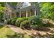 Manicured front yard featuring a covered porch, flowering bushes, and a brick pathway at 102 Treadwell Ct, Cary, NC 27513