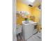 Bright laundry room with modern washer and dryer, storage shelves, and a utility sink at 102 Treadwell Ct, Cary, NC 27513