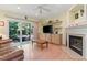 Cozy living room with a fireplace, built-in shelves, hardwood floors, and a sliding glass door to the patio at 102 Treadwell Ct, Cary, NC 27513