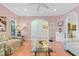 Spacious living room with pink walls, hardwood floors, an arched doorway, and comfortable seating at 102 Treadwell Ct, Cary, NC 27513