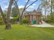 View of backyard, featuring a wooden deck, green garage door and well manicured lawn at 1024 W Markham Ave, Durham, NC 27701