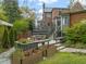 Outdoor deck area featuring a dining table, flower beds, and stairs to backyard at 1024 W Markham Ave, Durham, NC 27701