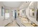 Well-lit bathroom features dual sinks, white cabinets, and shower with blue accent wall at 1024 W Markham Ave, Durham, NC 27701