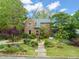 Beautiful brick home with mature trees, stone walkway, and manicured front yard at 1024 W Markham Ave, Durham, NC 27701