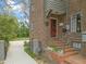 Brick home featuring a red front door and brick steps leading up to the entrance, with a long driveway and landscaped yard at 1024 W Markham Ave, Durham, NC 27701