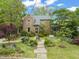 Beautiful brick home with mature trees, stone walkway, and manicured front yard at 1024 W Markham Ave, Durham, NC 27701