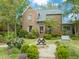 Charming brick home featuring professional landscaping, stone walkway, and a decorative water feature in the front yard at 1024 W Markham Ave, Durham, NC 27701