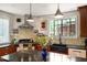 Modern kitchen with black marble island, custom cabinets, tiled backsplash, and stainless steel appliances at 1024 W Markham Ave, Durham, NC 27701