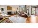 Cozy living room with a fireplace, hardwood floors, a leather sofa, and large windows providing plenty of natural light at 1024 W Markham Ave, Durham, NC 27701