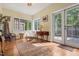 Bright sitting room with hardwood floors, a large window with black grids, and a glass-paned door to the outside at 1024 W Markham Ave, Durham, NC 27701