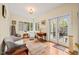 Bright sitting room with hardwood floors, a large window with black grids, and a glass-paned door to the outside at 1024 W Markham Ave, Durham, NC 27701