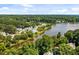 Scenic aerial view of lakeside homes nestled amidst lush green trees, offering tranquil waterfront living at 104 Silver Fox Ct, Cary, NC 27511