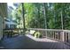 Relaxing back deck with wood flooring features seating, green foliage, and a view of the wooded backyard at 104 Silver Fox Ct, Cary, NC 27511