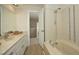 Neutral bathroom features tile flooring, a vanity with marble countertop, and a shower over tub with tile surround at 104 Silver Fox Ct, Cary, NC 27511