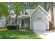 Inviting exterior of home with attached garage, complemented by lush landscaping and a charming facade at 104 Silver Fox Ct, Cary, NC 27511